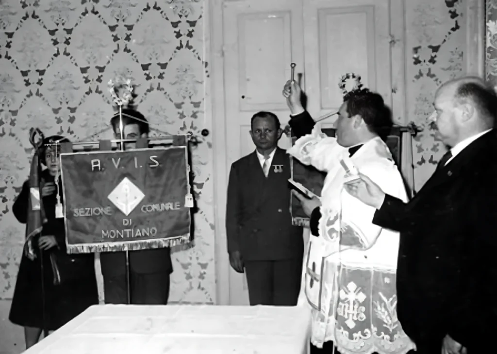 Il parroco don Alfredo Paganelli benedice la bandiera all’inaugurazione della sezione Avis del Comune di Montiano.